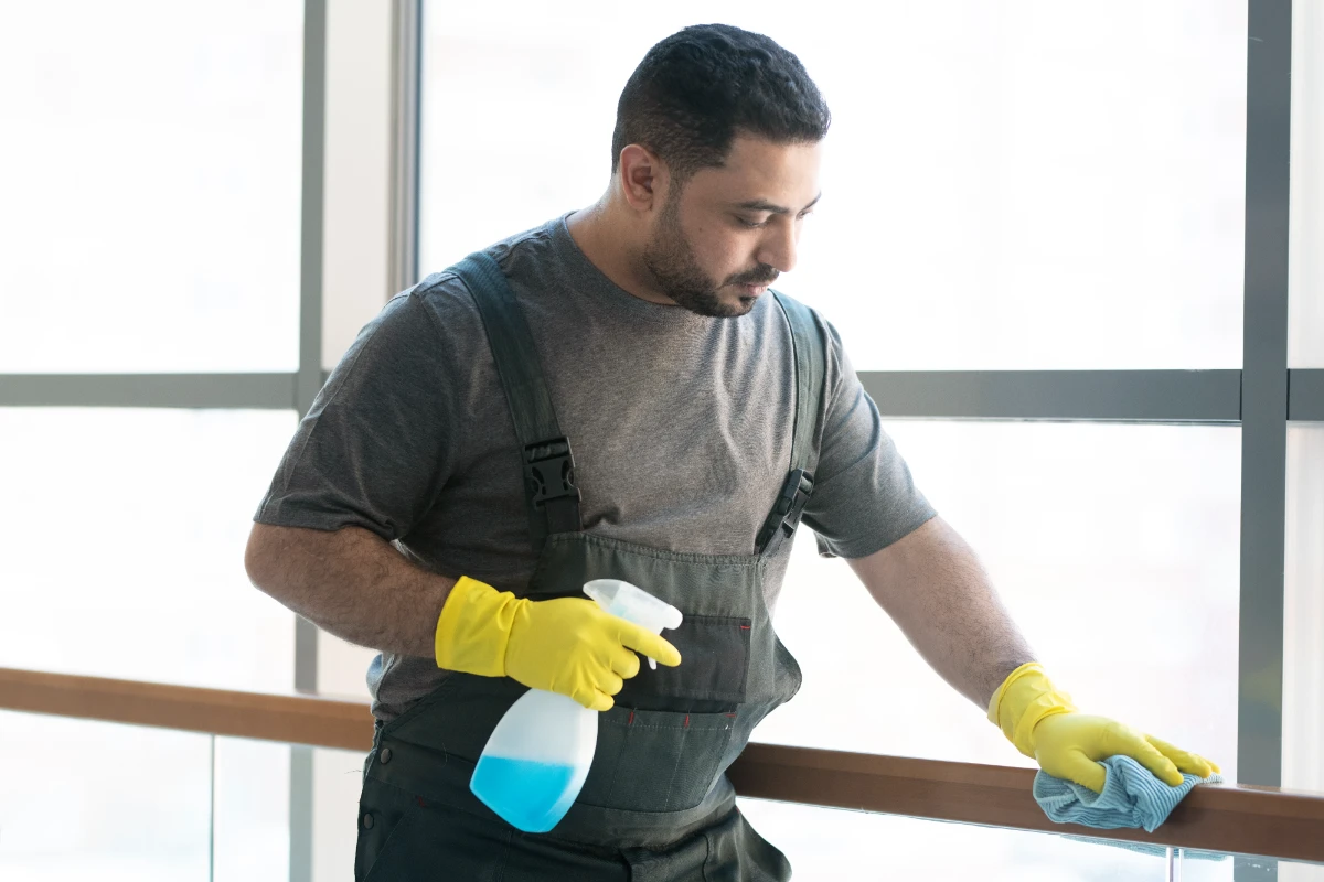 Medium shot man cleaning railing with cloth